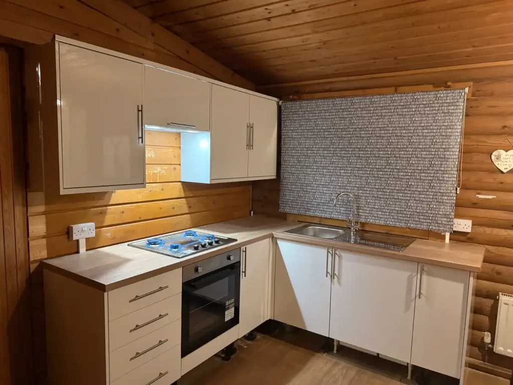 A fitted white kitchen in a timber lodge holiday let