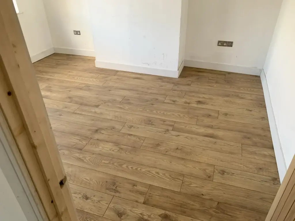 A new wood-effect LVT floor with new skirting in an empty room