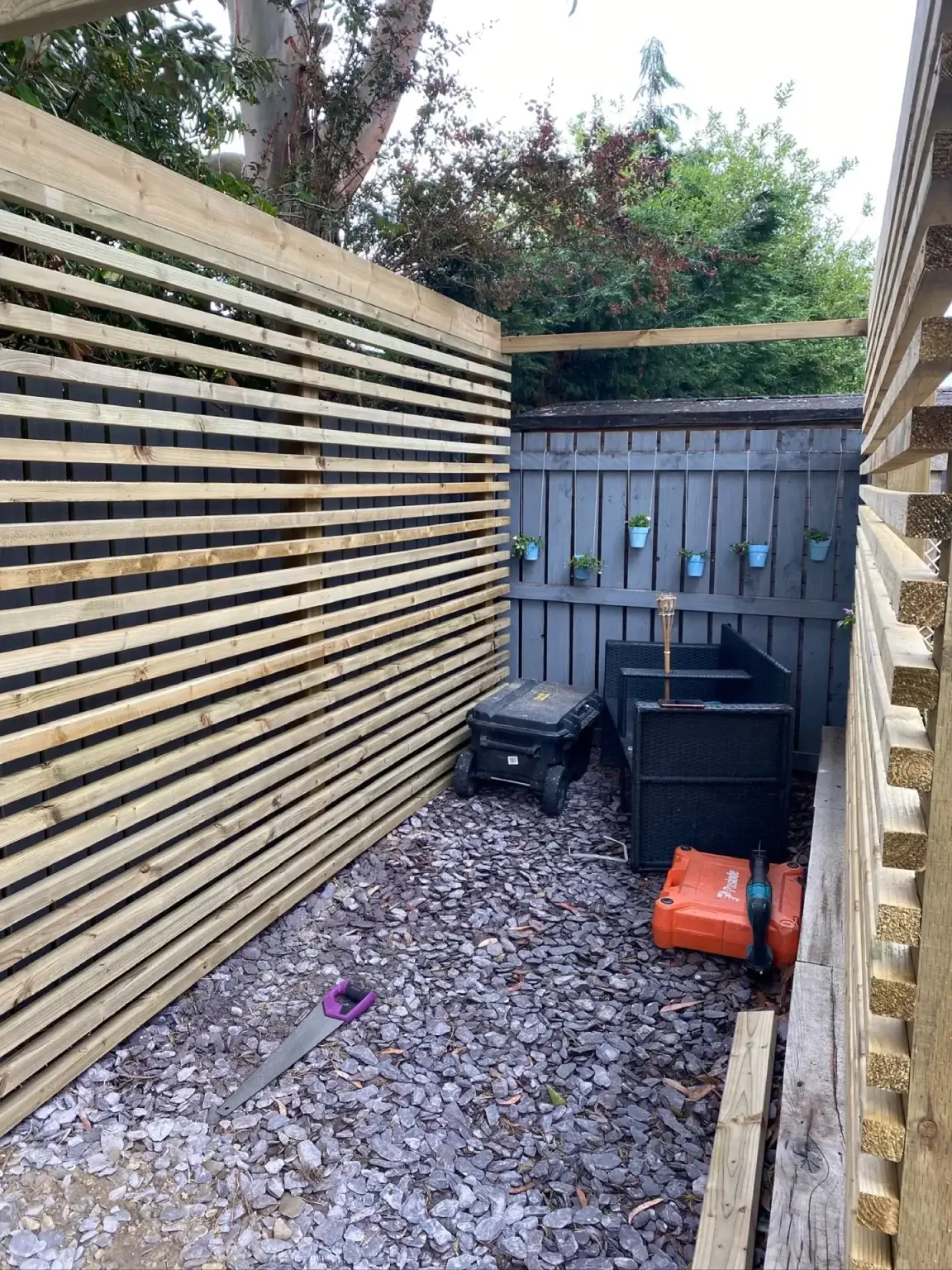 A slatted timber privacy pergola beside a garden path