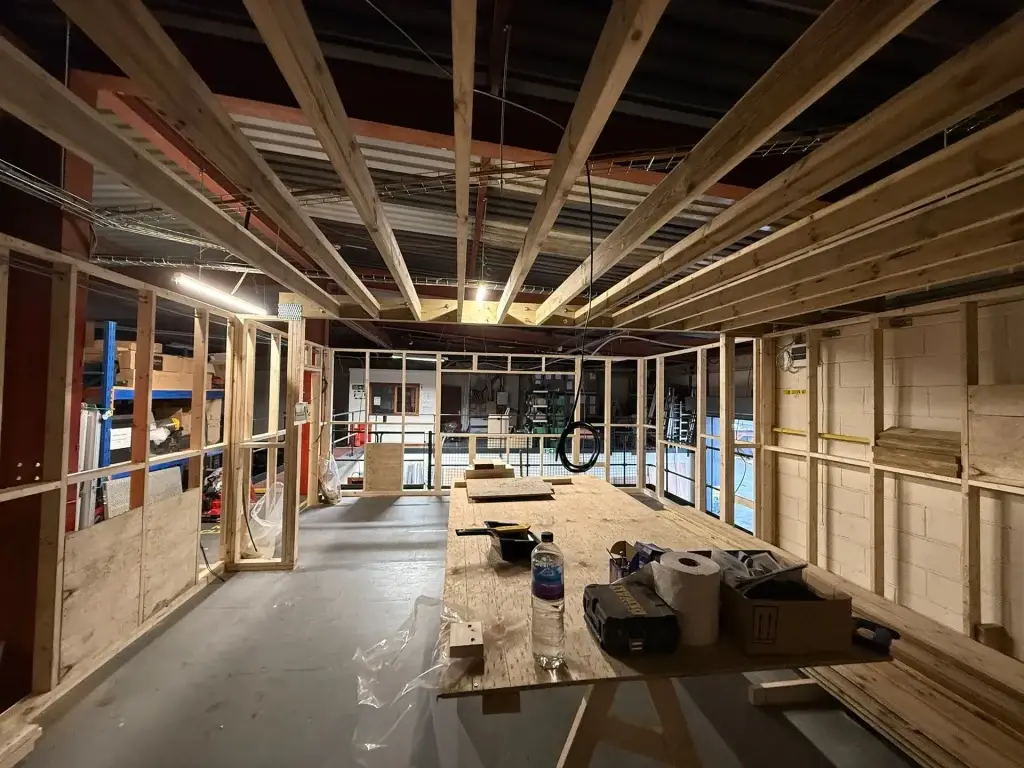 Timber stud partitions and ceiling joists framed out across a large open floor