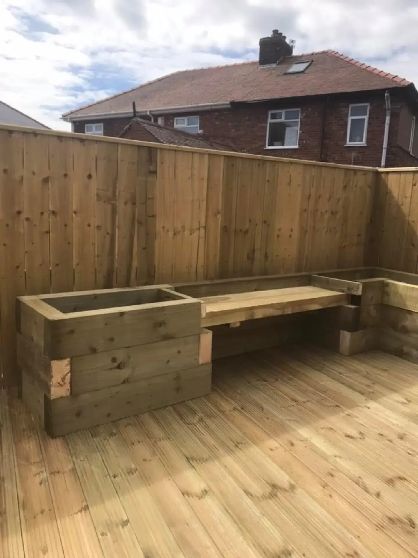 Built-in timber bench seating and a planter on a deck