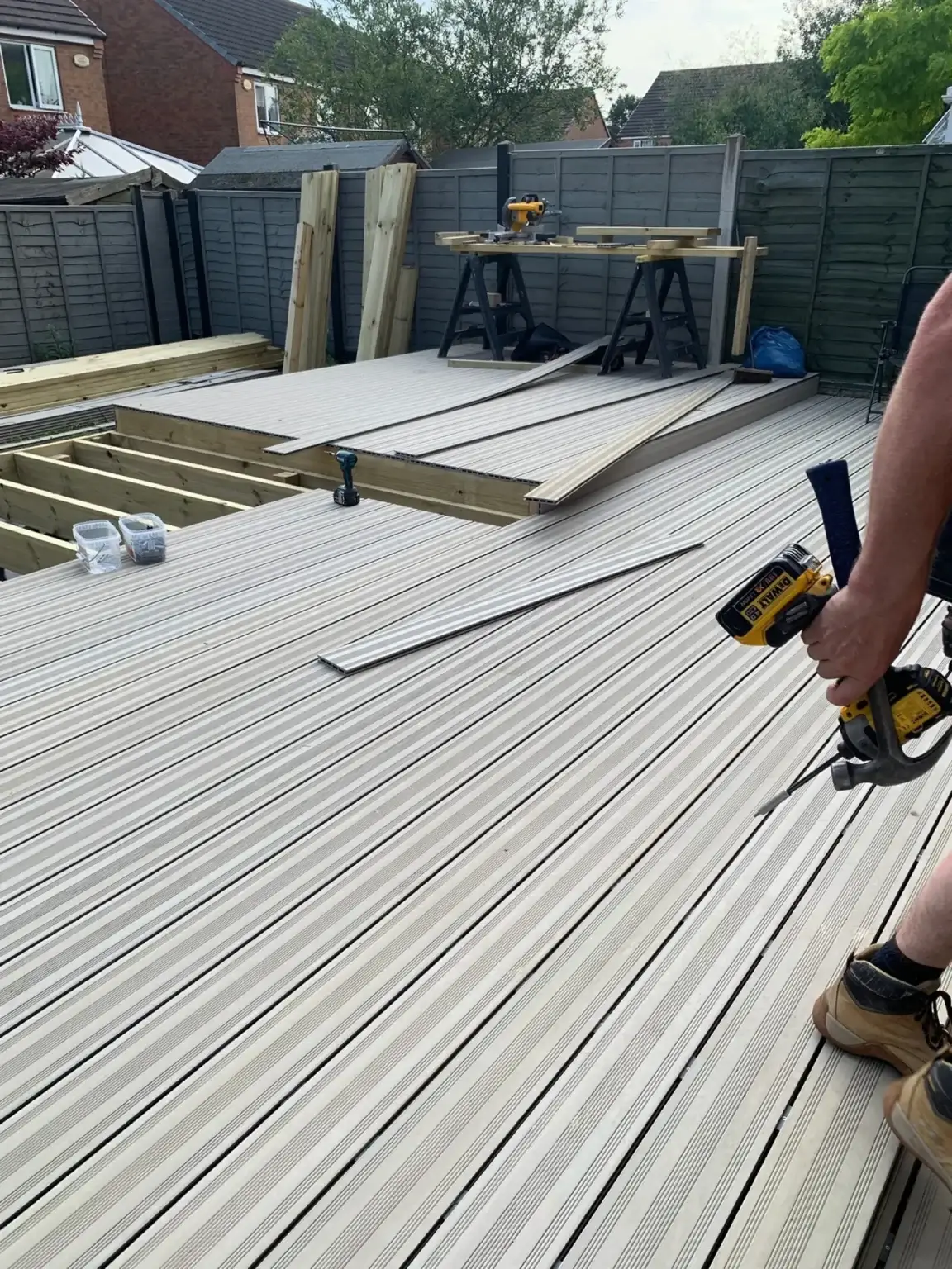 Grey composite decking boards being fixed down on a new deck