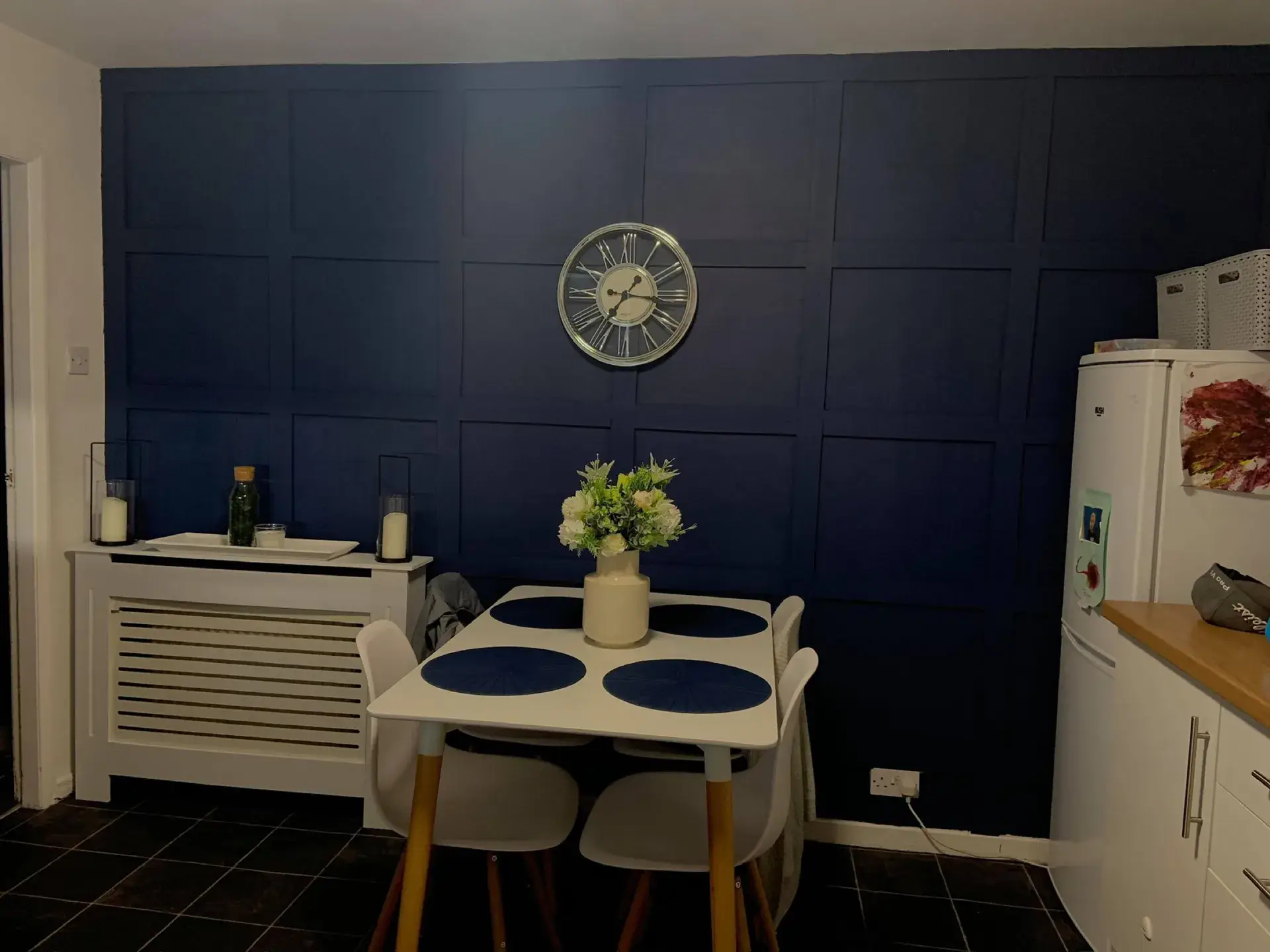 A dining area with a navy panelled wall