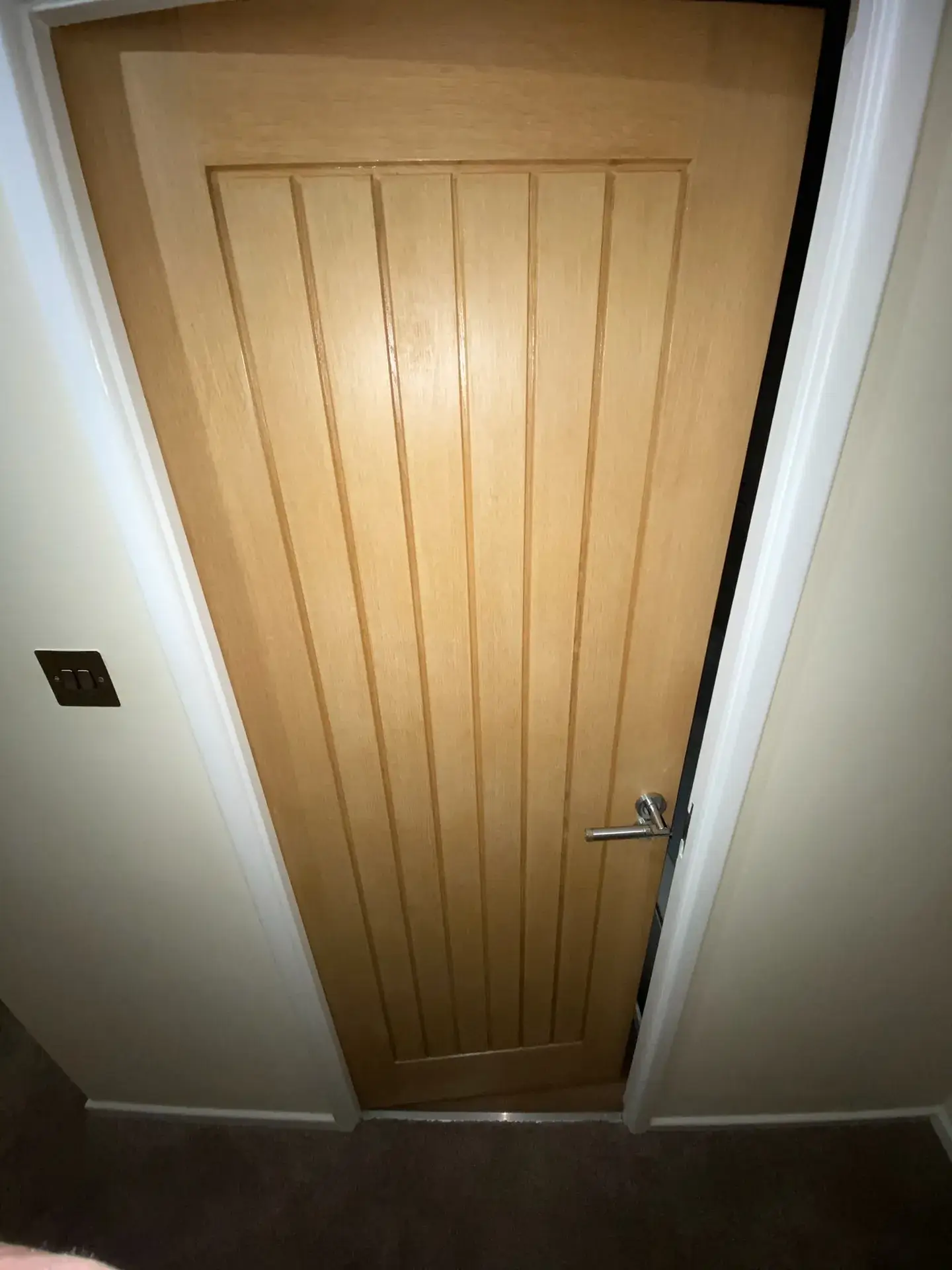 An oak internal door hung in a white painted frame and architrave